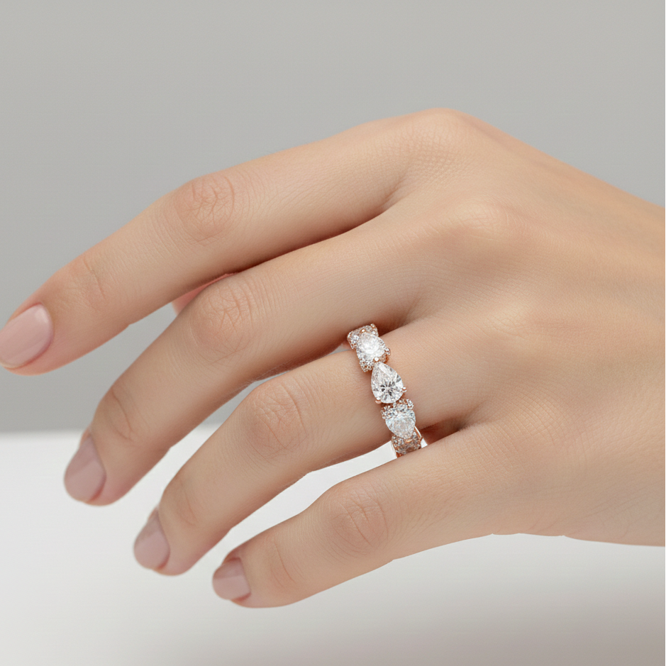 Hand wearing a diamond ring on a neutral background