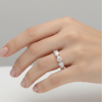Hand wearing a diamond ring on a neutral background