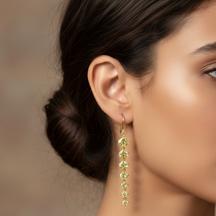 Close-up of a woman wearing gold earrings with green gemstones against a blurred background