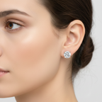 Close-up of a woman wearing a diamond stud earring on a neutral background