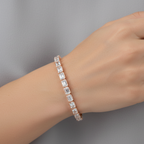 Hand wearing a diamond bracelet on a neutral background