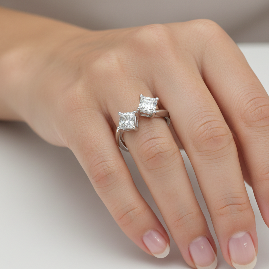 Hand wearing a diamond ring on a neutral background