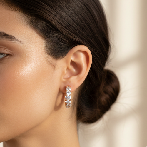 Close-up of a woman wearing diamond hoop earrings with a blurred background