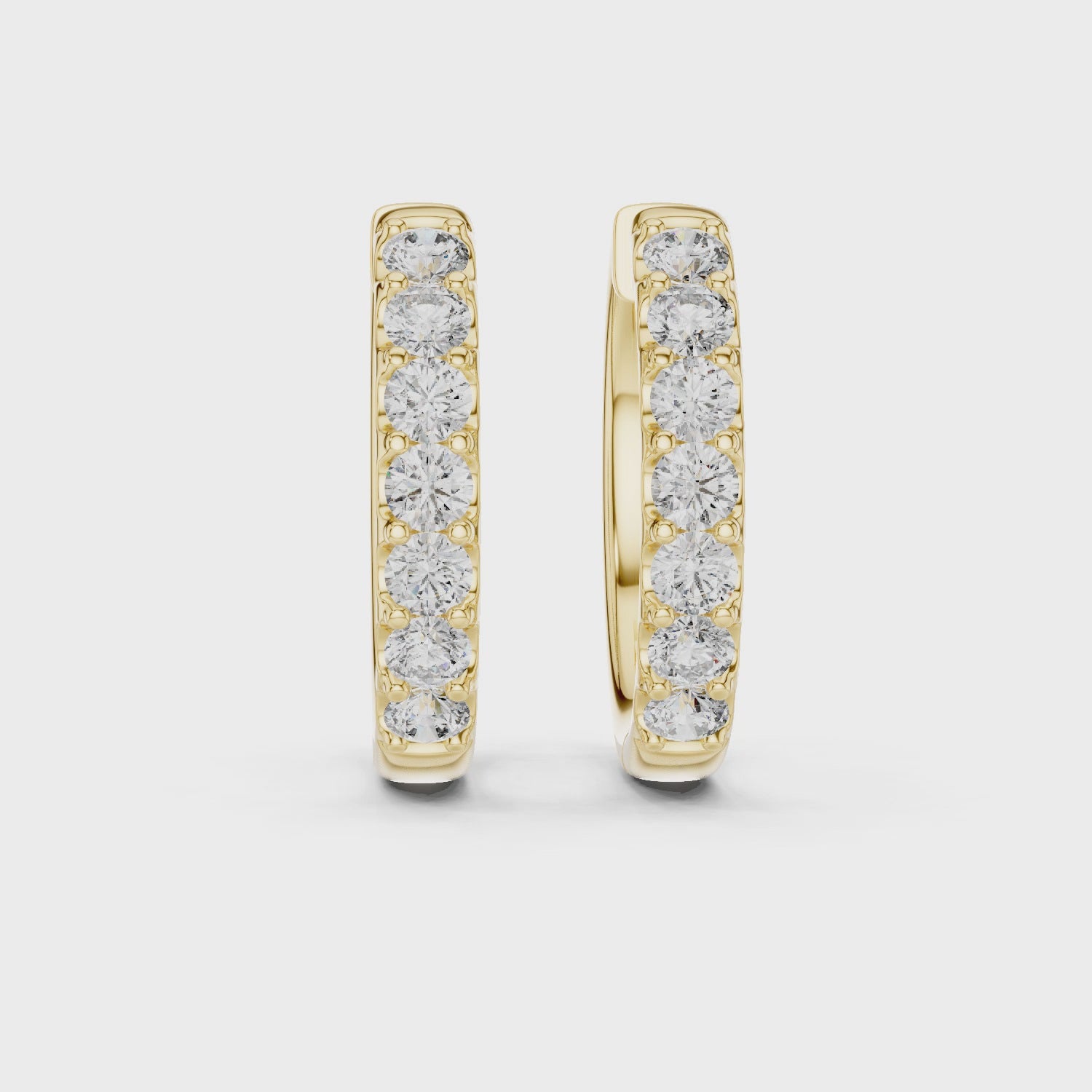 360 rotating video of Roy Diamond yellow gold diamond huggie hoop earrings with round diamonds and polished shine